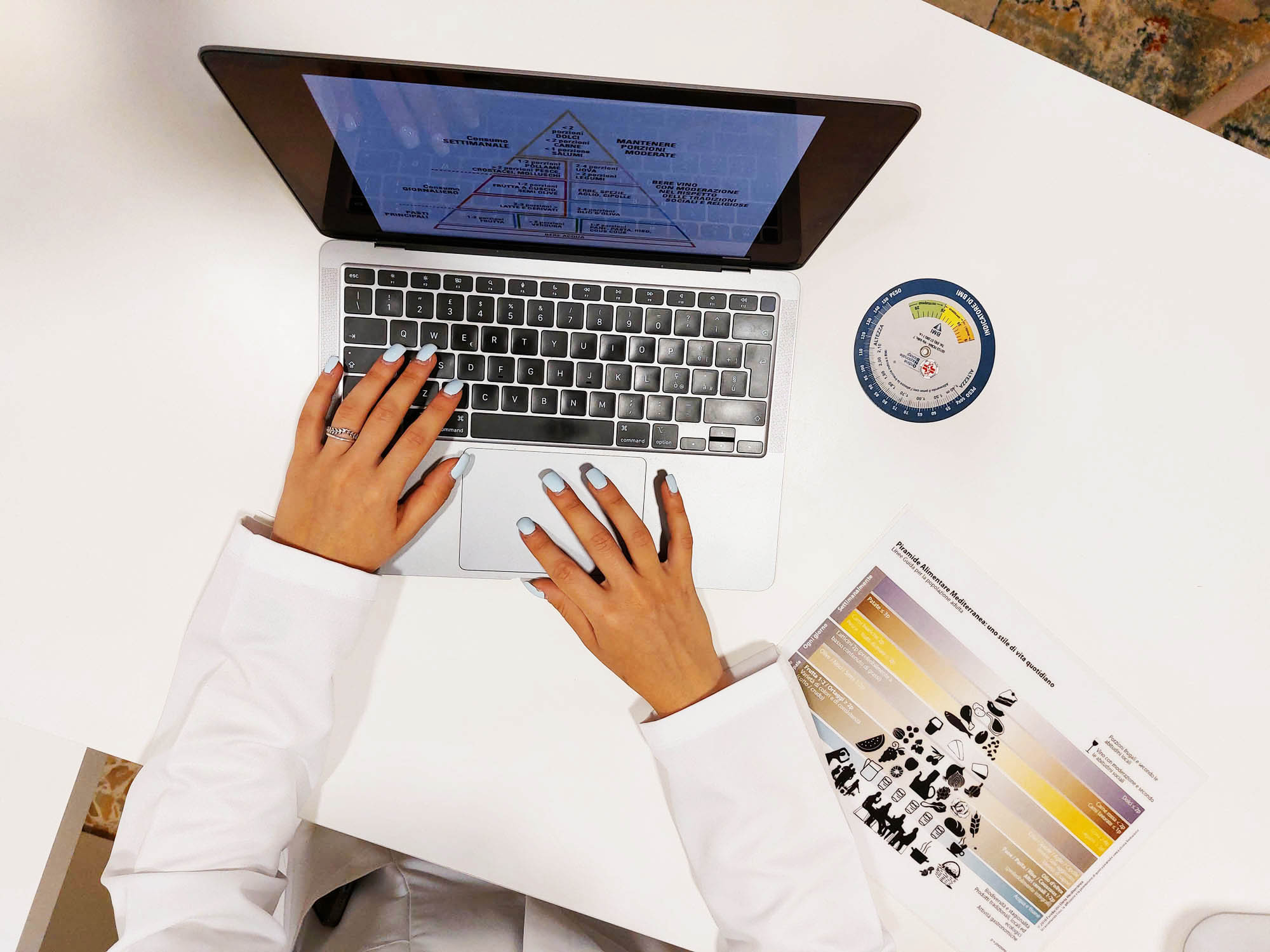 Servizio di consulenza nutrizionale online - Biologa Nutrizionista Ascoli Piceno Consulenza nutrizionale online - Dott.ssa Alessandra Armili al lavoro con piramide alimentare mediterranea e strumenti professionali